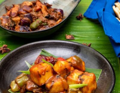 Two curry dishes laid out on a banana lead at INDUS