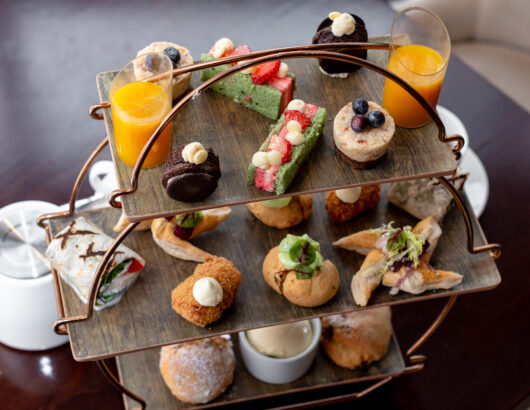three-tier afternoon tea with scones, savoury pastries and mini cakes