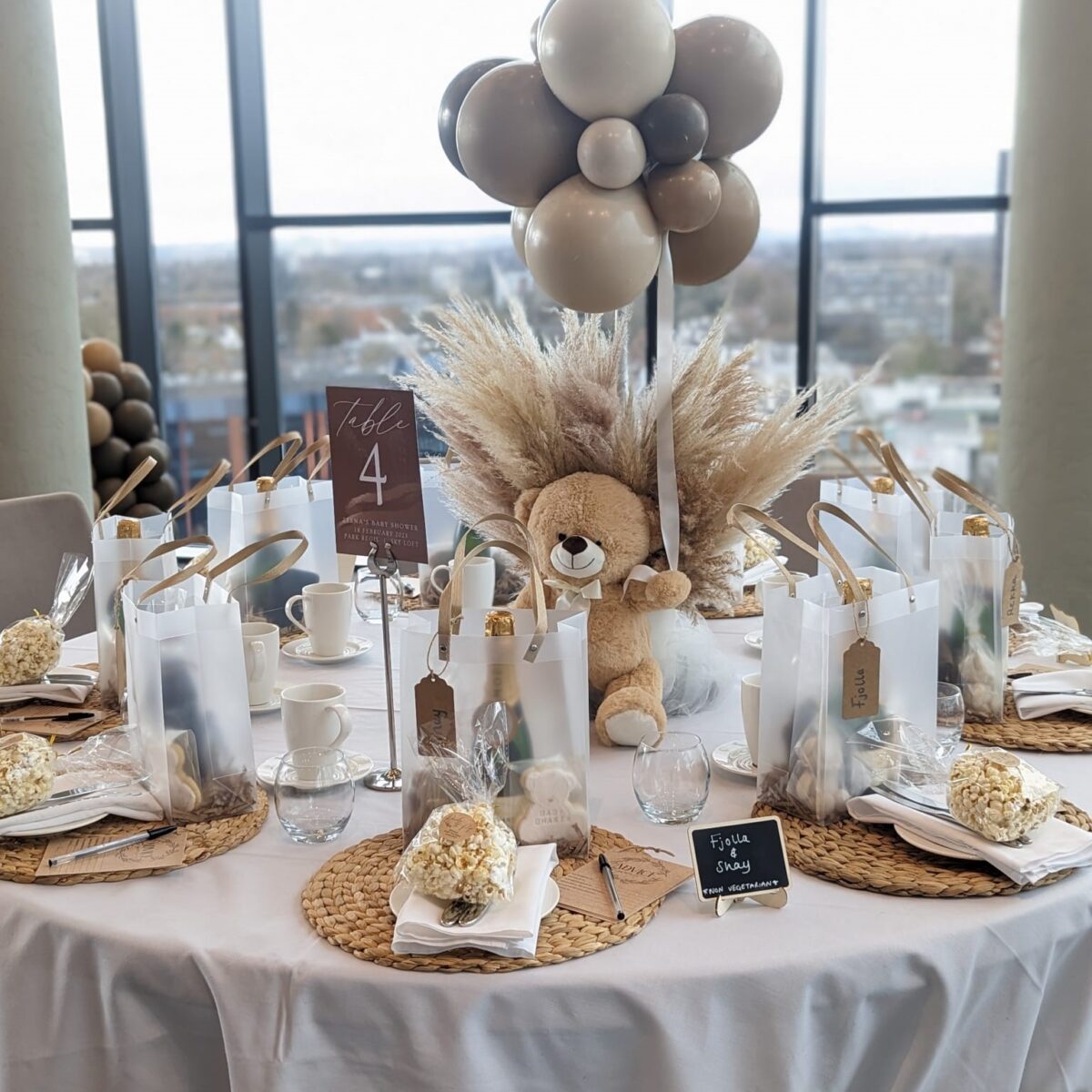 Baby shower with a table decorated with balloons and a teddy