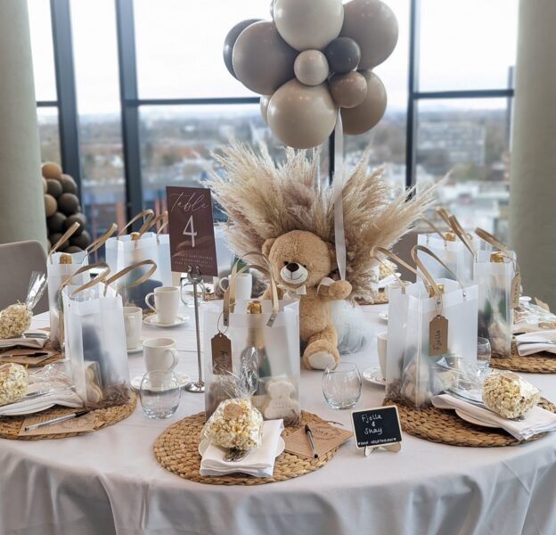 Baby shower with a table decorated with balloons and a teddy