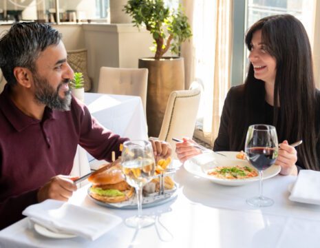 two people enjoying dinner and smiling