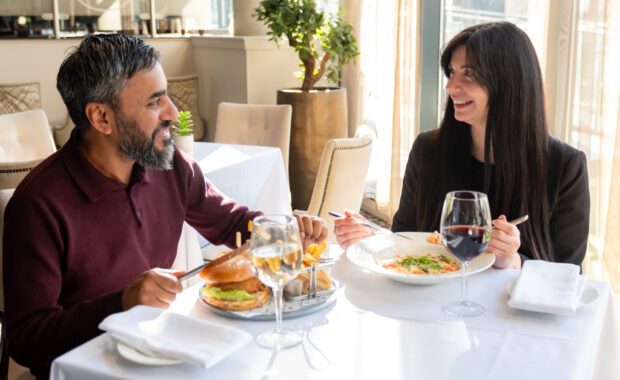 two people enjoying dinner and smiling