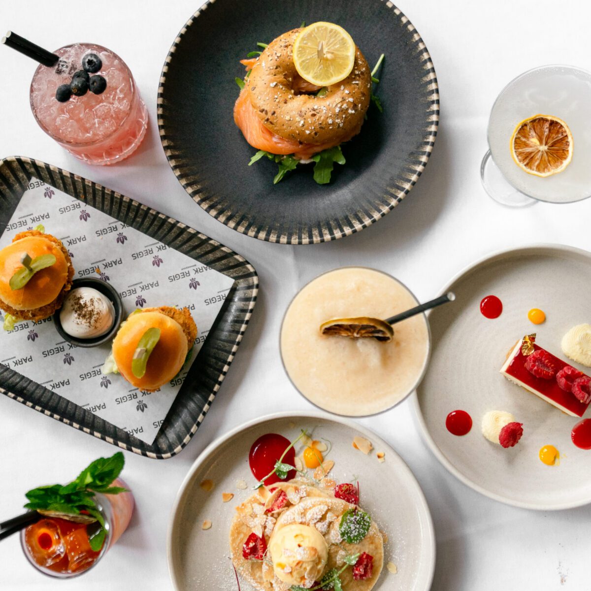 Bottomless brunch dishes including a smoked salmon bagel, chicken burger sliders, cheesecake, pancakes as well as four cocktails